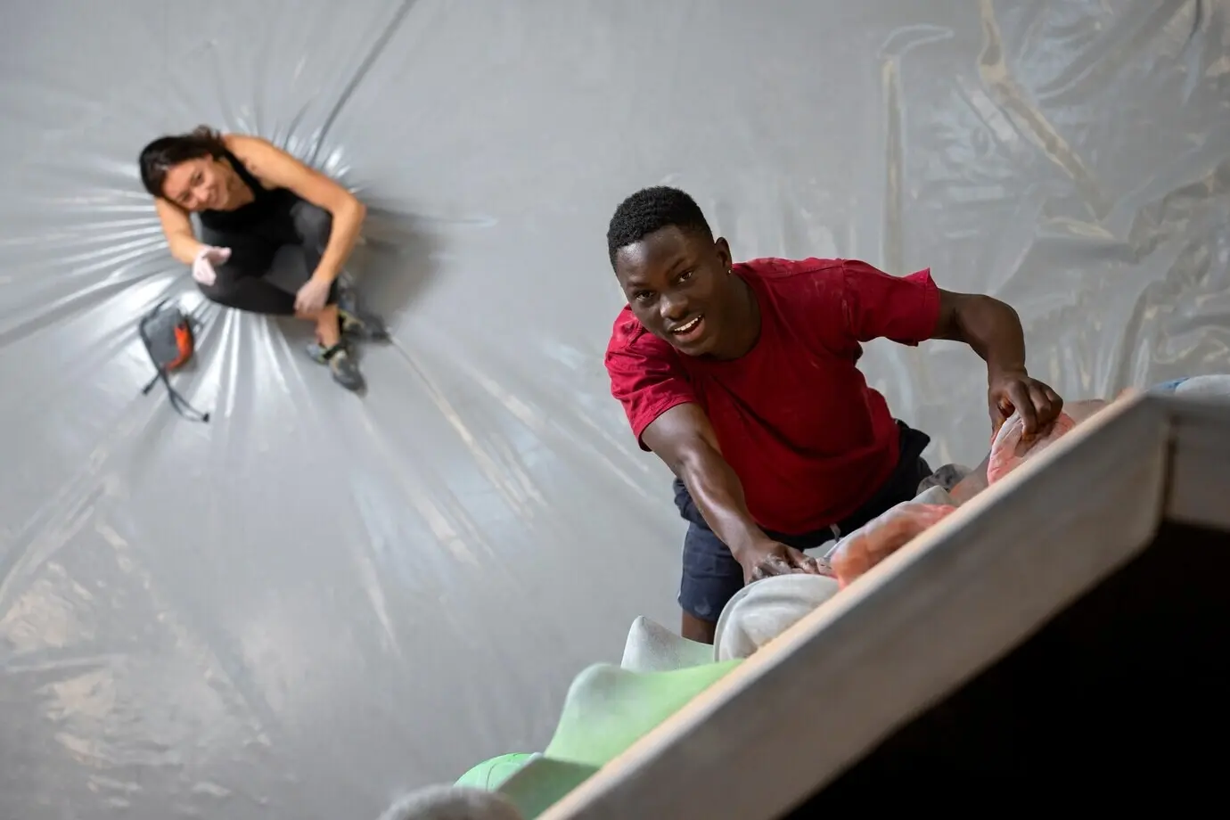 Ganzkörperaufnahme eines Mannes, der eine Wand hinaufklettert.